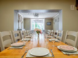 A dining room with a long table set for a meal at Milton Manor in Milton On Stour