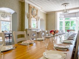 A dining room with a large table set for a meal at Milton Manor in Milton On Stour