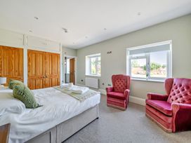 A bedroom with a bed and two chairs at Milton Manor in Milton On Stour