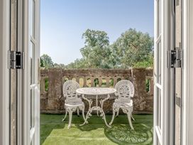 A balcony with a table and chairs at Milton Manor in Milton On Stour