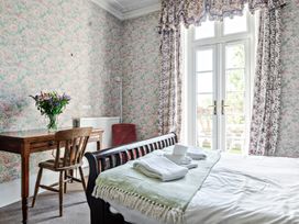 A bedroom with a bed and table at Milton Manor in Milton On Stour
