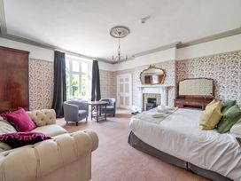 A bedroom with a bed, sofa and seating area at Milton Manor in Milton On Stour