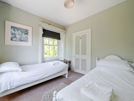 A bedroom with two beds and a window at Milton Manor in Milton On Stour