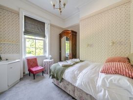 A bedroom with a bed and a chair at Milton Manor in Milton On Stour