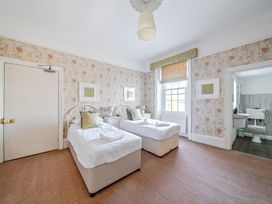 A bedroom with two beds and an adjoining bathroom at Milton Manor in Milton On Stour