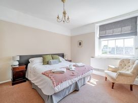 A bedroom with a bed and a chair at Milton Manor in Milton On Stour