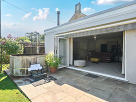 An outdoor area with a hot tub and sliding doors at Milton Manor in Milton On Stour