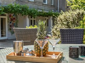 An outdoor area with a tray, pineapple and glassware at Milton Manor Milton On Stour