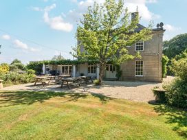 A house with picnic tables and a tree in the garden at Milton Manor in Milton On Stour