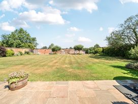 A garden with grass and trees at Milton Manor in Milton On Stour