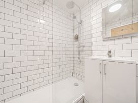 A bathroom with a shower area and white subway tiles at The Boars Head Pub in Bishops Castle