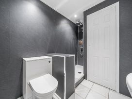 A bathroom with a toilet a walk in shower and a white door at The Boars Head Pub in Bishops Castle