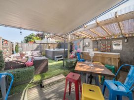 An outdoor seating area with colorful chairs tables a wooden bar and a hot tub at The Boars Head Pub in Bishops Castle