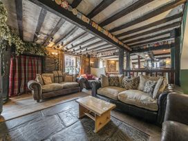 A pub lounge with sofas stone floor wooden coffee table and timber beam ceiling at The Boars Head Pub Bishop's Castle