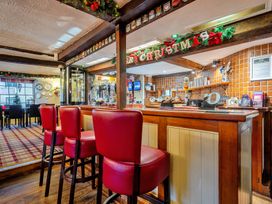 A bar area with stools and beer taps at The Boars Head Pub in Bishop's Castle