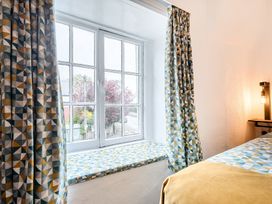 A bedroom with a window and patterned curtains at The Boars Head Pub in Bishop's Castle