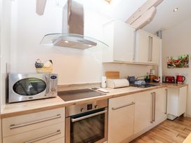 A kitchen with a microwave oven, cooker, and kitchen cabinets at Tregona Buckland Monachorum near Yelverton