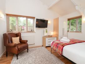 A bedroom with a bed and armchair at Tregona Buckland Monachorum near Yelverton