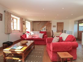 A living room with red sofas and a coffee table at Bramble Cottage in Somerton