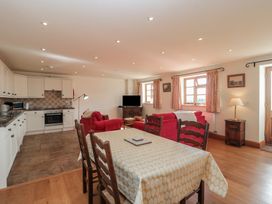 A kitchen and dining area with seating and appliances at Bramble Cottage in Somerton