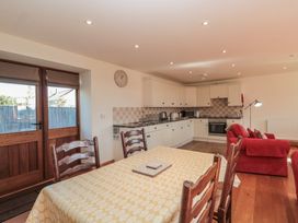 A kitchen with a dining table and appliances at Bramble Cottage in Somerton
