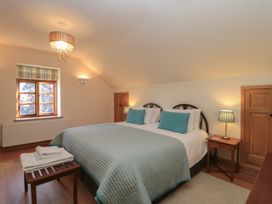 A bedroom with a bed and window at Bramble Cottage in Somerton