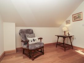 A snug with a rocking chair and a side table at Bramble Cottage in Somerton