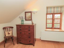 A bedroom with a dresser and a chair at Bramble Cottage in Babcary near Lydford-On-Fosse