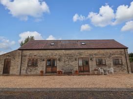 An outdoor area with a stone building and seating at Badger Cottage in Lydford-On-Fosse