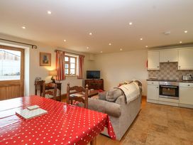 A living room with table and sofa at Badger Cottage in Lydford-On-Fosse