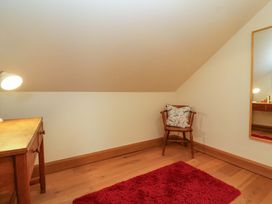 An attic space with a desk and chair at Badger Cottage in Lydford-On-Fosse