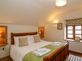A bedroom with a bed and window at Badger Cottage in Lydford-On-Fosse