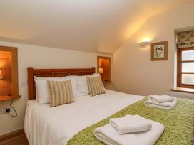 A bedroom with a double bed and a window at Badger Cottage in Lydford-On-Fosse