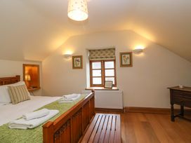 A bedroom with a bed and table at Badger Cottage Lydford-On-Fosse