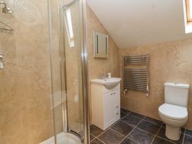 A bathroom with shower, sink, toilet, and towel rail at Badger Cottage in Lydford-On-Fosse