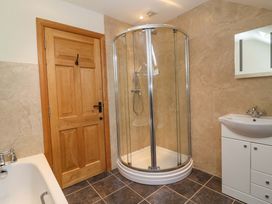 A bathroom with a shower, bathtub, and sink at Badger Cottage in Lydford-On-Fosse