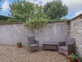 A garden with two chairs and a table at Badger Cottage Lydford-On-Fosse