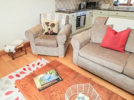 A living room with an armchair and sofa at Badger Cottage in Babcary near Lydford-On-Fosse