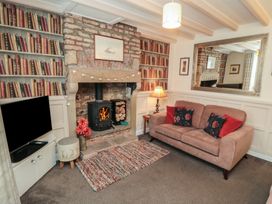 A living room with a fireplace and bookshelf at Dove Cottage in Pickering