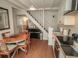 A kitchen with a dining table and stairs at Dove Cottage in Pickering