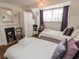 A bedroom with two beds and a wardrobe at Dove Cottage in Pickering