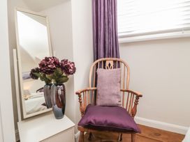 A chair with a pillow and flowers on a vase in the bedroom at Dove Cottage in Pickering