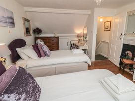 A bedroom with two beds and a mirror at Dove Cottage in Pickering