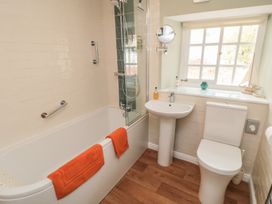 A bathroom with a bathtub, shower, toilet, and sink at Dove Cottage in Pickering