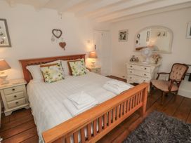 A bedroom with a bed and nightstands at Dove Cottage in Pickering