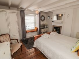 A bedroom with a bed and decorative mirror at Dove Cottage in Pickering