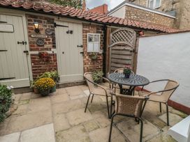 A patio with a table and chairs at Dove Cottage in Pickering