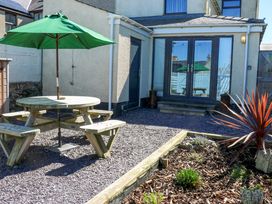 An outdoor area with a picnic table and umbrella at Rhiwlas Rhosneigr
