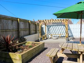 An outdoor space with a bench and table at Rhiwlas in Rhosneigr