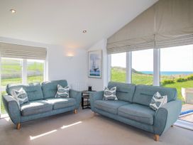 A living room with sofas and a view at 7 Ocean's Edge in Thurlestone